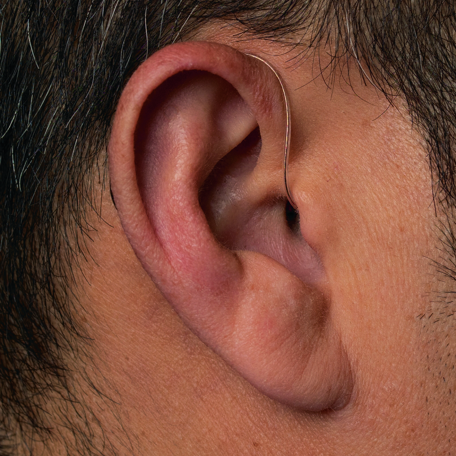 The same Phonak Receiver-in-Canal worn behind the ear, with the thin wire passing into the canal